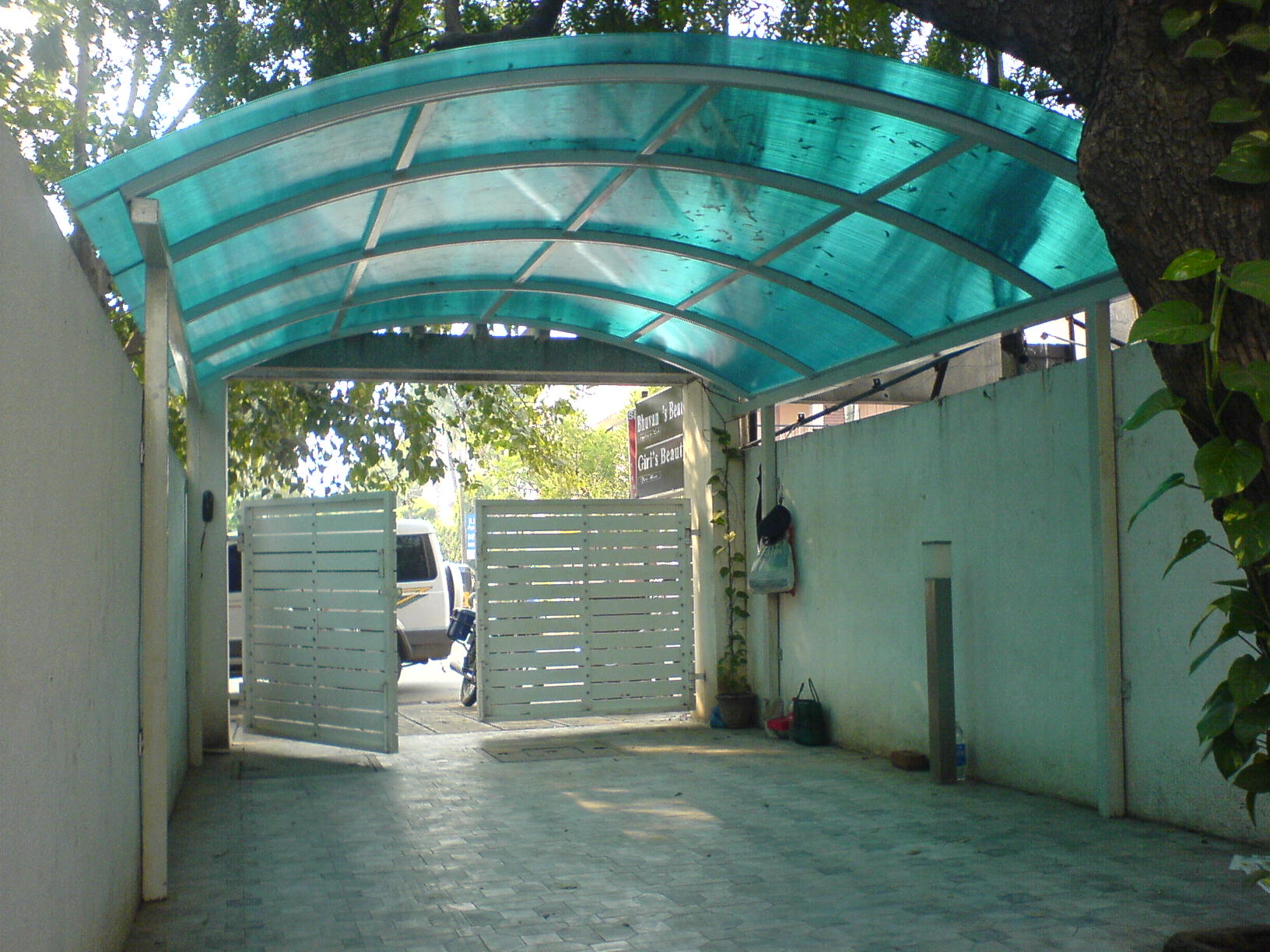Blue polycarbonate sheet car parking canopy installed at a residential property by Arasuvel Roofings